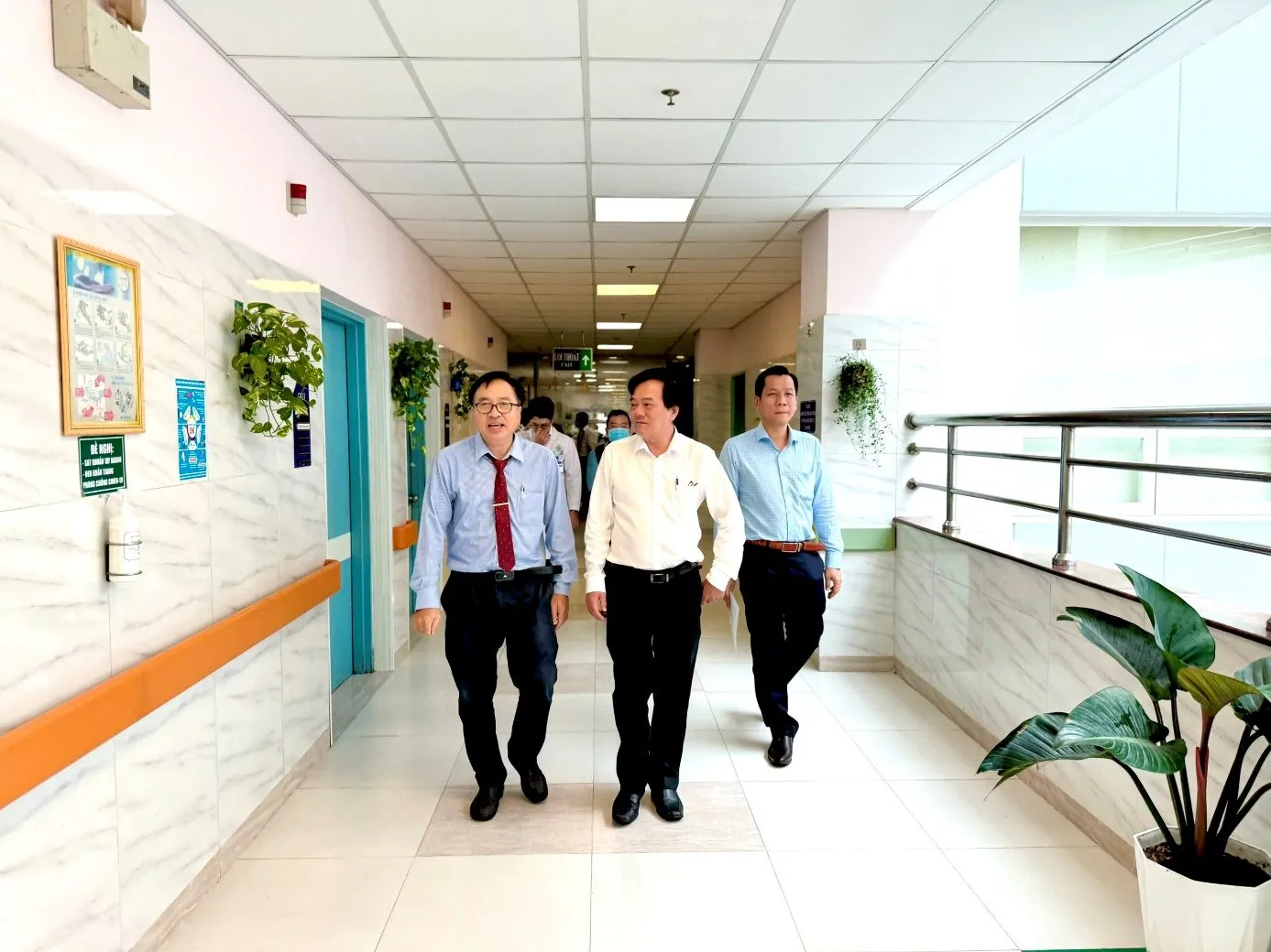 A group of men walking in a hallway

Description automatically generated