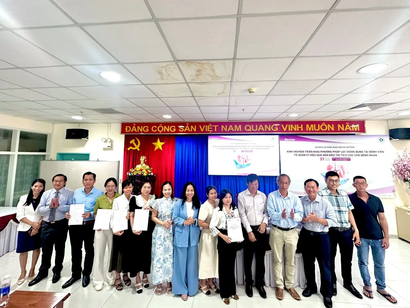 A group of people standing in front of a banner

Description automatically generated