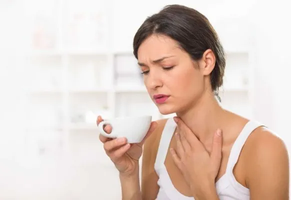A person holding a cup of tea Description automatically generated